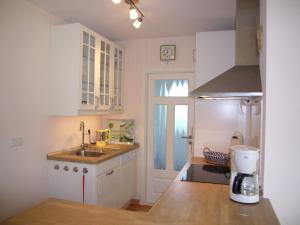 a small kitchen with white cabinets and a sink at _BIR14_ Haus am Birkenweg in Niendorf