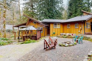 a house with a picnic table and chairs in front of it at Creekside Cabin in Rhododendron