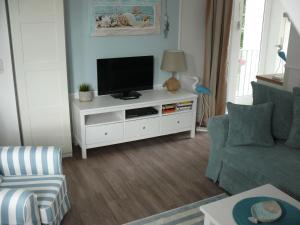 ein Wohnzimmer mit einem TV auf einem weißen Schrank in der Unterkunft (WIK7a) in Niendorf