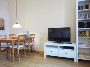 a living room with a television and a dining room table at Ferienwohnung Am Molli Nr. 4 in Kühlungsborn