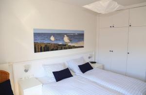 WittenbeckにあるFerienwohnung Sonnenblickのベッドルーム1室(ベッド2台付)が備わります。壁に鳥が2羽