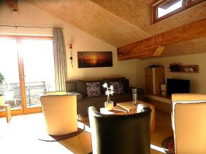 ein Wohnzimmer mit einem Sofa, einem Tisch und Stühlen in der Unterkunft PENTHOUSE with mountain views and SAUNA in Hermagor