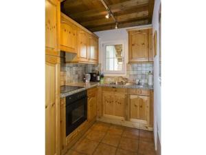 a kitchen with wooden cabinets and a stove top oven at in the Ella Storta house in Surcuolm