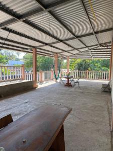 a large patio with a wooden table and a hammock at Hotel Pacific Surf The Best Room in Tunco Beach Surf City in Tamanique