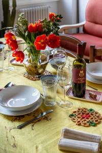 una mesa con flores rojas y una botella de vino en San Giovanni Apartment, en Florencia