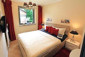 1 dormitorio con 1 cama grande con almohadas rojas en Chalet Jägerstieg, en Braunlage