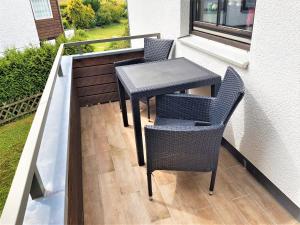 a table and chairs on a balcony with a window at Chalet Jägerstieg in Braunlage