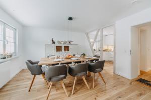a kitchen and dining room with a wooden table and chairs at Villa Luna Braunlage in Braunlage +12 photos