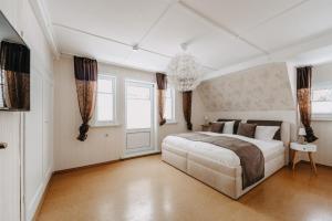 a bedroom with a large white bed and windows at Villa Luna Braunlage in Braunlage
