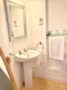 y baño con lavabo, espejo y ducha. en Highfield Guesthouse, en Skipton