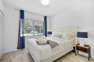 ein Schlafzimmer mit einem weißen Bett und einem Fenster in der Unterkunft Santorini Pool House Wilton Manors Walk to the Dr in Fort Lauderdale