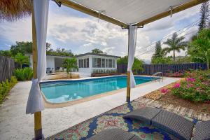 einen Pool mit einer Pergola neben einem Haus in der Unterkunft Santorini Pool House Wilton Manors Walk to the Dr in Fort Lauderdale