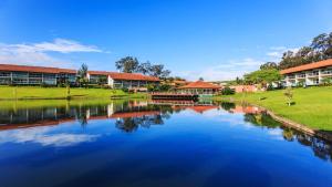 um rio em frente a um campus com edifícios em Villa Hípica Resort em Gravatá