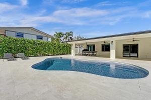 a swimming pool in front of a house at Once Upon a Tide - Just Minutes to the Beach in Dania Beach