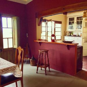 a kitchen with purple walls and a bar with a stool at La Madreselva in San Antonio de Areco