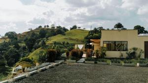 ein Haus mit einem Hügel im Hintergrund in der Unterkunft Casa Río Quindío in La Tebaida