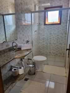a bathroom with a toilet and a glass shower at Morada dos ipes in Monte Verde +16 photos