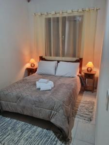 a bedroom with a bed with two white objects on it at Morada dos ipes in Monte Verde