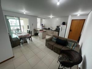 a living room with a couch and a kitchen at Home Club , frente mar in Piçarras