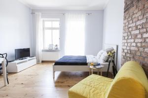 a bedroom with a bed and a brick wall at Homewell Apartments Pod Szczerbatym in Poznań