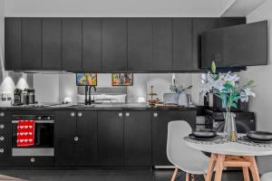 a kitchen with black cabinets and a table with chairs at V's Cosy Retreat in Broadview