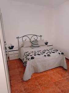 a bedroom with a bed with a black and white comforter at Casa rural Mccoy 2 in Macael