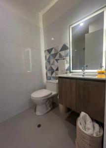uma casa de banho com um WC, um lavatório e um espelho. em Dormitorio privado súper acogedor y una gran vista a la Ciudad em Lima