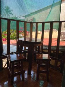 a table and two stools on a balcony with a view at Hotel Pacific Surf Tunco Beach with AC best room Surf City in Tamanique