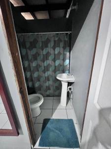 uma pequena casa de banho com lavatório e WC em Hotel Pacific Surf Tunco Beach with AC best room Surf City em Tamanique