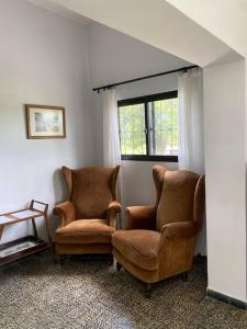 two chairs sitting in a room with a window at Doña Hilda casa de campo in Mercedes