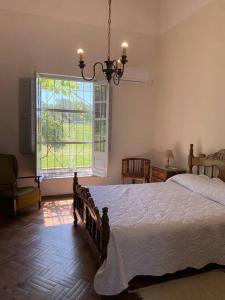 um quarto com uma cama e uma grande janela em Doña Hilda casa de campo em Mercedes