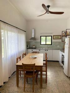 a kitchen with a table with chairs and a ceiling fan at Doña Hilda casa de campo in Mercedes