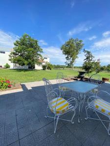 a table and chairs on a patio with a field at Doña Hilda casa de campo in Mercedes