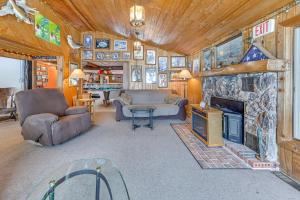 a living room with a stone fireplace in a house at Lakefront Suring Home with Pool Table and Views! in Mountain