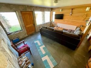 a living room with a couch and a television at Cabañas Paraíso in Puerto Tranquilo