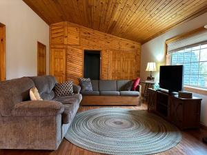 a living room with a couch and a tv at Modern Getaway cabin, sleeps 7 Near Meadville in Guys Mills