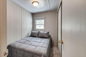 een bed in een kleine kamer met een raam bij Rhinelander Vacation Rental with Yard on Venus Lake! in Rhinelander