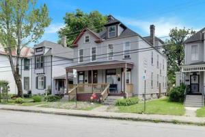 a large white house on the corner of a street at Housepitality - The Madison House - Brand New in Columbus