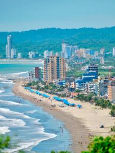 vistas a una playa con personas y edificios en EDIFICIO LOS DELFINES Walk to the Beach en Atacames