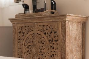 een houten doos met een houtsnijwerk aan de zijkant bij Zahra Superior Suite with private pool in Sannicola