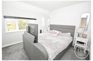 a bedroom with a bed and a window at Modern three bed house in Ditchingham
