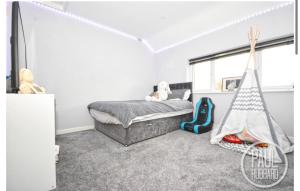 a bedroom with a bed and a play tent at Modern three bed house in Ditchingham