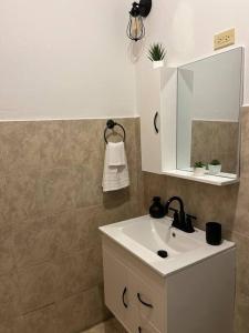 a bathroom with a white sink and a mirror at La Casandra Beach House in Isabela