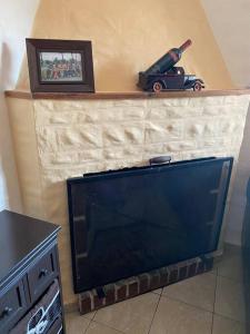 a tv with a toy car on top of a fireplace at Casa de dos plantas in Mercedes