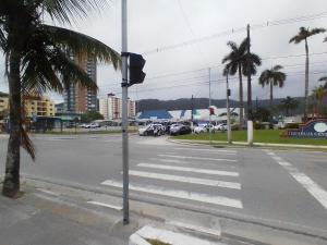une rue vide avec un palmier et une promenade dans l'établissement Home Enseada Beach, à Guarujá