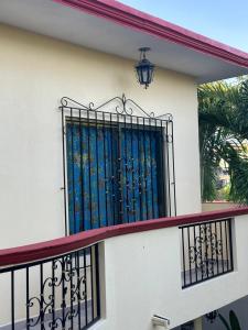 un balcón con una puerta de acero azul en una casa en Departamento acogedor en Cunduacán
