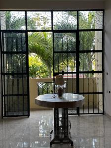 Habitación con mesa frente a una ventana grande. en Departamento acogedor en Cunduacán