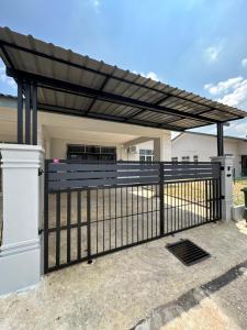 a pergola over a fence in front of a house at D’ QR Homestay Kuantan in Kuantan