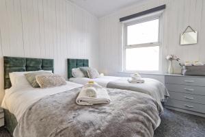 um quarto com 2 camas e toalhas em Beautiful Spacious four bedroom house with parking for 2 cars, 5 minute walk to southend station em Southend-on-Sea