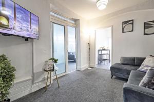 sala de estar con sofá y TV de pantalla plana en Beautiful Spacious four bedroom house with parking for 2 cars, 5 minute walk to southend station en Southend-on-Sea